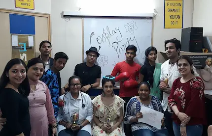 Spoken english students striking poses post-performance in a costume play party