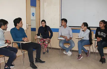 Spoken english students in a group discussion, sharing ideas to improve fluency.